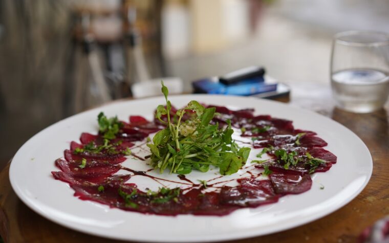 Rote-Bete-Carpaccio auf einem Teller als Bild zum Rezept mit Ziegenkäse, Granatapfel und Walnüssen